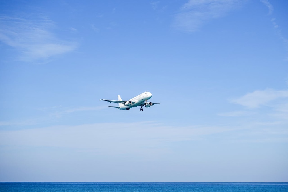 Plane flying low over a beach