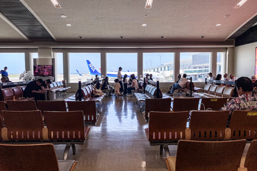 People waiting for their flight at an airport in Okinawa, Japan